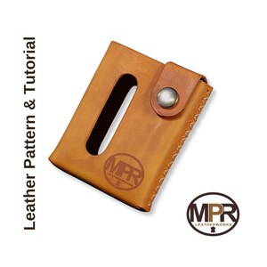 Puede incluir: Una cartera de cuero marr&oacute;n con cierre a presi&oacute;n y un recorte para una tarjeta. La cartera tiene un borde cosido y el logotipo "MPR Leatherworks" est&aacute; estampado en la parte delantera.