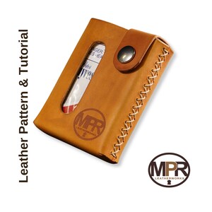 Puede incluir: Una cartera de cuero marr&oacute;n con un borde cosido y una peque&ntilde;a ventana para una tarjeta de cr&eacute;dito. La cartera tiene un cierre a presi&oacute;n y un logotipo que dice "MPR Leatherworks".