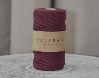 May include: A roll of deep burgundy cotton cord, wrapped in brown paper with the text "Bilibag Factory" printed on it.