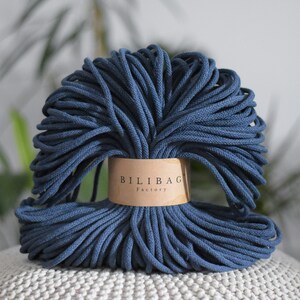 Puede incluir: Primer plano de un rollo de cuerda de algodón azul oscuro con una etiqueta marrón que dice "Bilibag Factory".