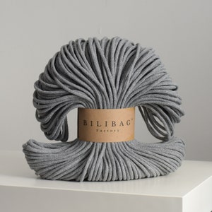 May include: A grey cotton cord, wound into a circle, with a brown label that reads "Bilibag Factory".