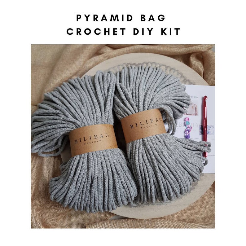 May include: A DIY crochet kit for making a pyramid bag. The kit includes two balls of gray cotton rope, a crochet hook, and instructions. The rope is labeled "Bilibag Factory".