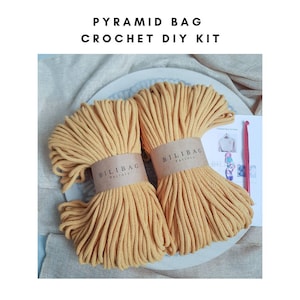 May include: A crochet DIY kit for making a pyramid bag. The kit includes two balls of yellow cotton rope, a crochet hook, and instructions. The rope is labeled "Bilibag Factory".