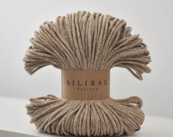 May include: A close-up of a spool of beige cotton rope with a brown paper label that reads "BILIBAG Factory".
