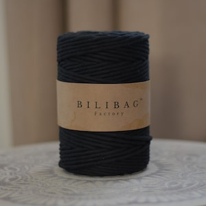 Może przedstawiać: Szpula czarnego sznurka bawełnianego z brązową etykietą z napisem "BILIBAG™ Factory".