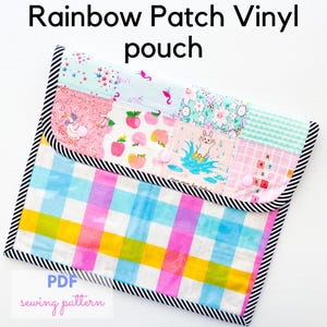 May include: A colorful vinyl pouch with a patchwork design. The top features various patterned squares with images of apples, unicorns, and a rabbit. The bottom has a rainbow plaid pattern. The pouch is outlined with a black and white striped trim. Text on the pouch reads "Rainbow Patch Vinyl pouch" and "PDF sewing pattern."