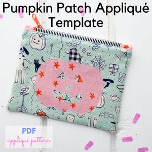 May include: A rectangular, light blue zippered pouch with a Halloween-themed pattern. The pouch features a pink pumpkin appliqué with orange star accents. Text on the pouch reads "Pumpkin Patch Appliqué Template" and "PDF appliqué pattern".