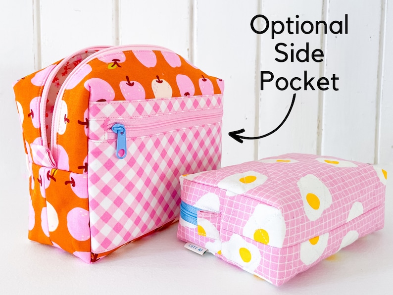 May include: Two fabric cosmetic bags. One is orange with pink apple designs and a pink gingham panel. The other is pink with fried egg designs. Both have pink zippers. Text reads "Optional Side Pocket".
