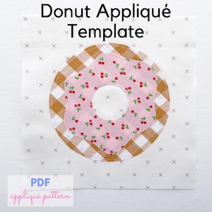 Könnte beinhalten: Eine Stoff-Donut-Applikationsvorlage mit dem Text "Donut Appliqué Template". Der Donut hat ein rosa Kirschmuster auf einem braun-weiß karierten Muster. Die Worte "PDF appliqué pattern" sind ebenfalls sichtbar.