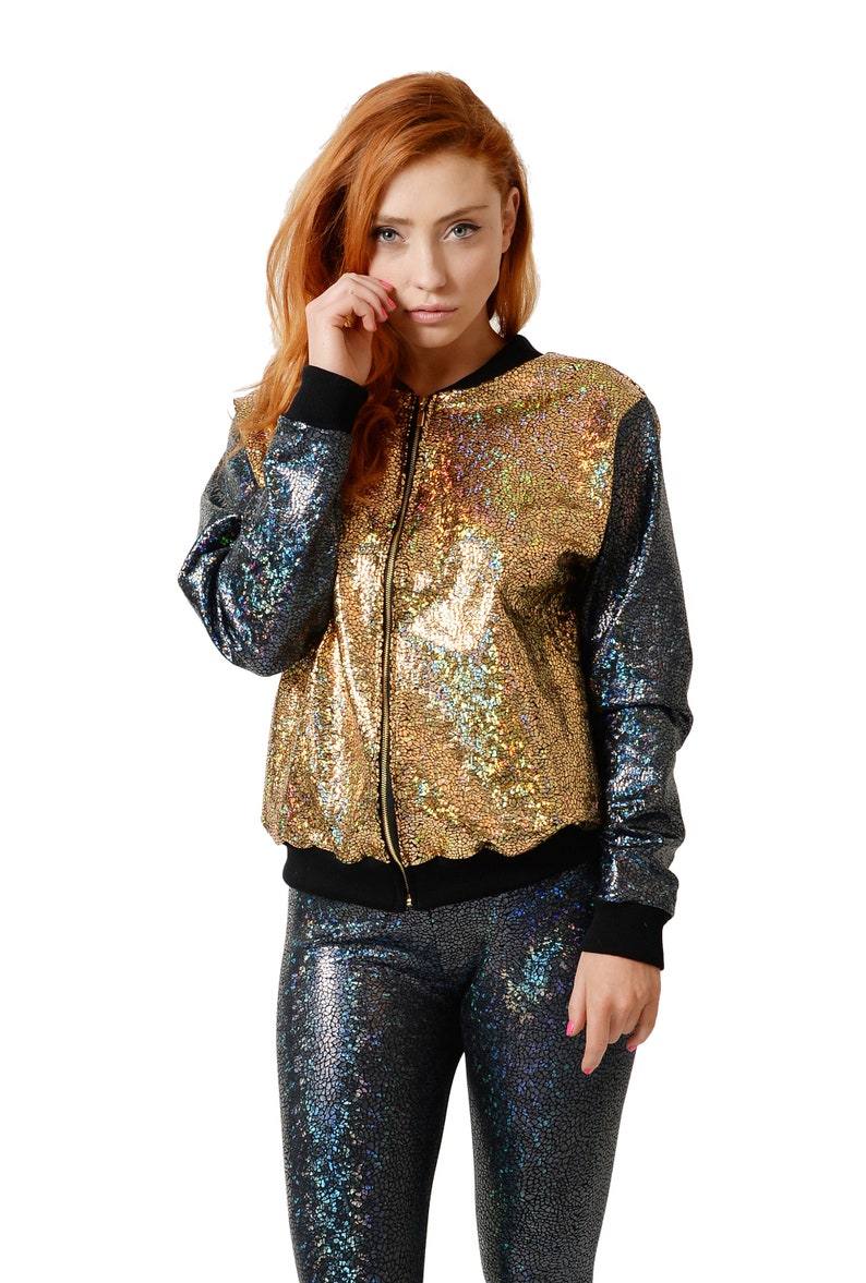 May include: A gold and black sequined bomber jacket with a zipper closure. The jacket has a iridescent sheen.