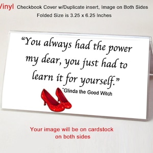 May include: A white checkbook cover with a quote from Glinda the Good Witch from the Wizard of Oz: "You always had the power my dear, you just had to learn it for yourself." The quote is printed in black cursive font. The cover is 3.25 inches by 6.25 inches and is made of vinyl. The image will be printed on cardstock on both sides.