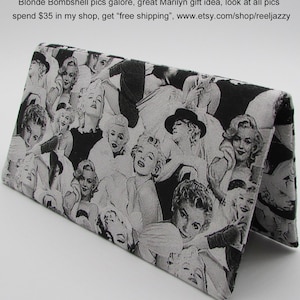 May include: A fabric checkbook cover or money holder featuring a black and white collage of Marilyn Monroe images. The cover is folded open, showcasing the repeating pattern of the iconic actress. The text on the image says "gorgeous Marilyn Monroe fabric Checkbook Cover/Coupon or Money Holder".