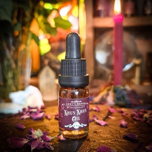 Könnte beinhalten: Eine kleine braune Glasflasche mit einem schwarzen Tropfer. Die Flasche ist mit "Ms. Grey's Emporium of Witchcraft Khus Khus Oil No. 933" beschriftet.