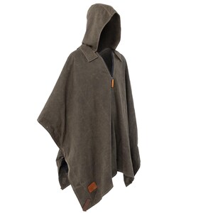 Puede incluir: Un poncho de lona marr&oacute;n con capucha, cierre de cremallera y detalles de cuero.
