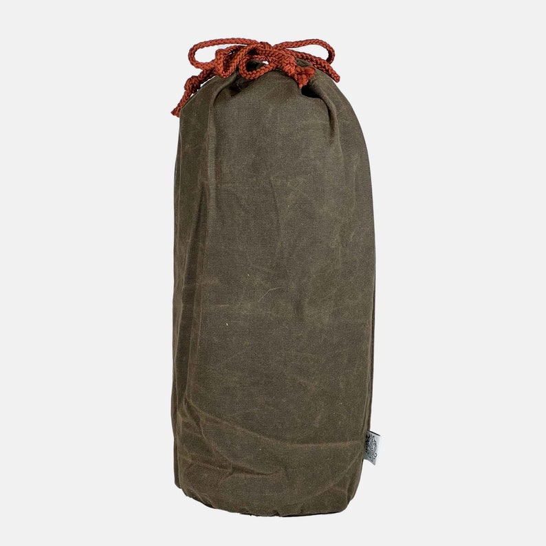 Puede incluir: Una bolsa de lona marr&oacute;n con cord&oacute;n de ajuste rojo. La bolsa est&aacute; vac&iacute;a y tiene una peque&ntilde;a etiqueta en el lateral.