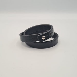 May include: A black leather wrap bracelet with a silver snap closure.