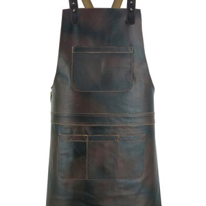 May include: A brown leather apron with adjustable straps and multiple pockets. The apron has a distressed look and is ideal for protecting clothes while working.