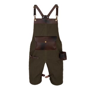 May include: A dark green apron with brown leather accents. Features include a large front pocket, a small side pocket, and adjustable straps. The apron is designed for work or craft use.