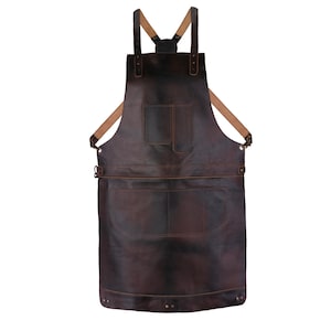 May include: A brown leather apron with adjustable straps and two large pockets. The apron has a distressed look and is made of high-quality leather.