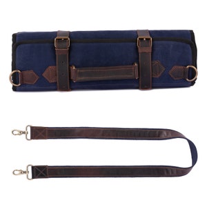 May include: A blue canvas roll-up bag with brown leather straps and buckles. The bag has a handle and an adjustable strap.