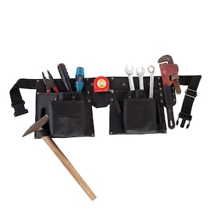Pode incluir: Cinto de ferramentas de couro preto com vários bolsos e várias ferramentas. As ferramentas incluem um martelo, alicates, chaves, uma fita métrica e uma chave de cano. O cinto tem uma alça e fivela pretas.