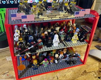 May include: A red three-tiered display shelf with a variety of miniature Lego figures. The top shelf features military figures with American flags. The middle shelf features Star Wars characters. The bottom shelf features Marvel characters.
