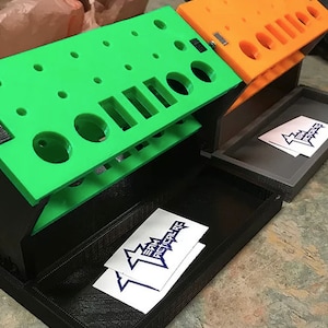 May include: A green and black tool organizer with a black tray and two stickers that say "Team Action RC".