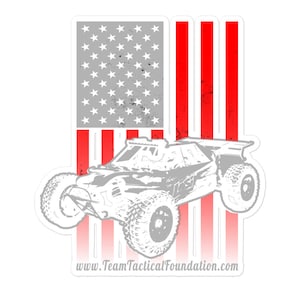 May include: A white silhouette of a race car with a red, white, and blue American flag background. The text "www.TeamTacticalFoundation.com" is at the bottom of the image.