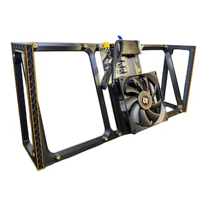 May include: Black and gold computer component frame with a black fan and circuit board. The frame has a geometric design with gold accents. The fan has a black blade and a logo in the center. The circuit board has various components and wires.
