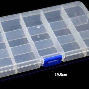 K&ouml;nnte beinhalten: Eine transparente Aufbewahrungsbox aus Kunststoff mit 16 F&auml;chern. Die Box hat einen blauen Verschluss an der Vorderseite und ist 19,5 cm lang.