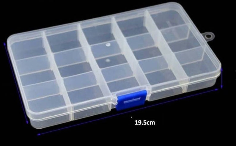 K&ouml;nnte beinhalten: Eine transparente Aufbewahrungsbox aus Kunststoff mit 16 F&auml;chern. Die Box hat einen blauen Verschluss an der Vorderseite und ist 19,5 cm lang.