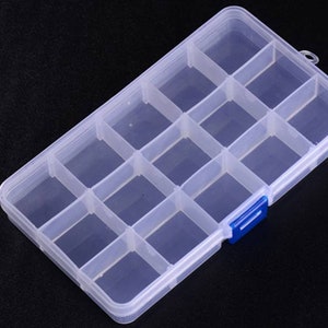 K&ouml;nnte beinhalten: Eine transparente Aufbewahrungsbox aus Kunststoff mit 12 F&auml;chern. Die Box hat einen blauen Verschluss an der Seite.