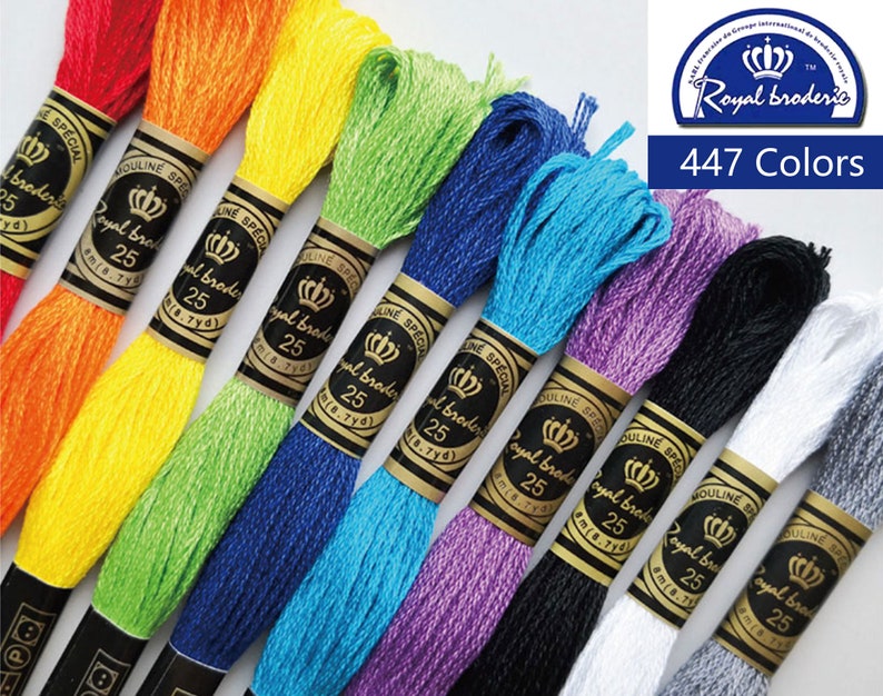 May include: A close-up of embroidery floss spools in various colors, including red, orange, yellow, green, blue, purple, black, white, and gray. The spools are labeled "Royal Broderie" and "Special Mouline" with a crown logo. The text "447 Colors" is visible in the upper right corner.