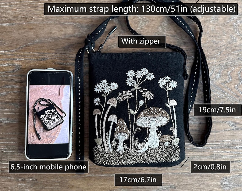 May include: A black fabric crossbody bag featuring white and brown embroidered mushrooms and wildflowers. The bag includes a zipper, an adjustable strap with a maximum length of 51 inches, and measures 7.5 inches by 6.7 inches by 0.8 inches.