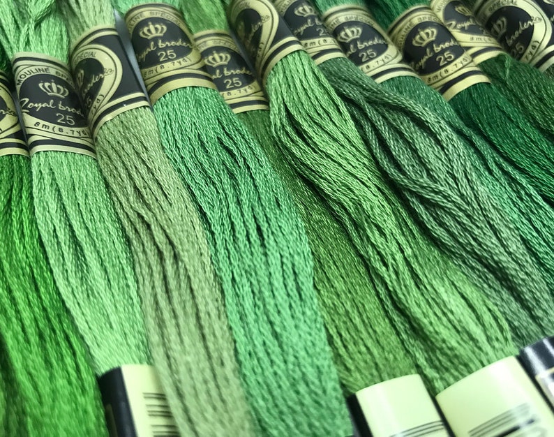 May include: A close-up of multiple spools of green embroidery floss. The spools are labeled "Royal Brode" and "25".