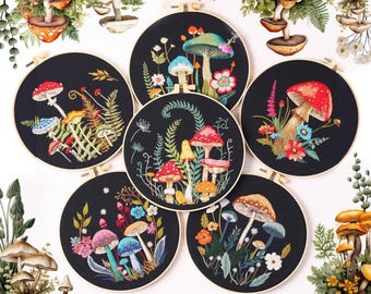 May include: Six embroidery hoops with black fabric and colorful embroidery of mushrooms and flowers. The hoops are arranged in a circle with the top hoop at the 12 o'clock position.
