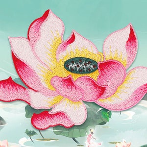 Op de afbeelding: Een geborduurde lotusbloem in roze en wit met een geel centrum. De bloem is op een lichtblauwe achtergrond met een witte wolk en een groen blad.