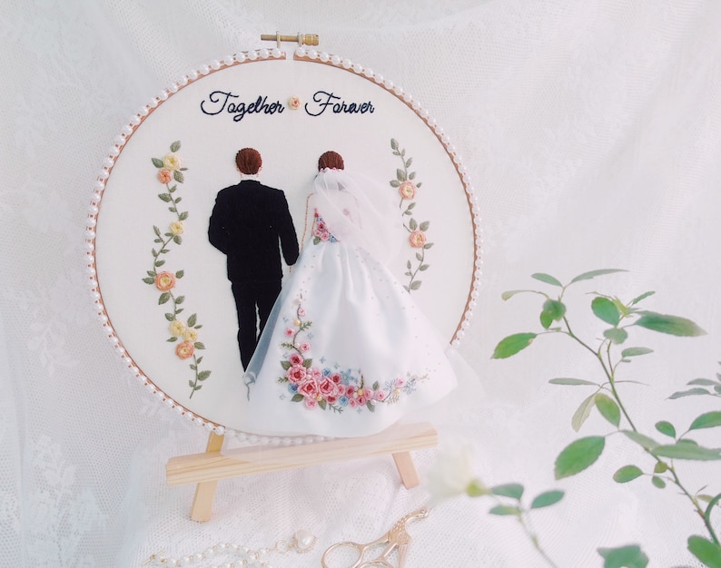 Pu&ograve; includere: Arte di ricamo a cerchio con una sposa e uno sposo in bianco e nero, con il testo "Together Forever" sopra. Il cerchio &egrave; decorato con perline di perle e ricamo floreale.