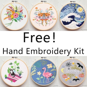 May include: Six embroidery hoops featuring various designs. The designs include a floral bouquet, a butterfly, a wave, a cat with plants, a flamingo with flowers, and a spooky Halloween scene. The hoops are all wooden and have a white background.