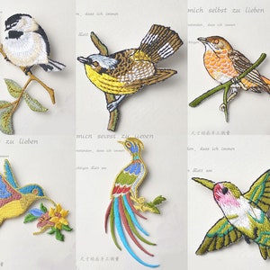 May include: Embroidered bird patches in various colors, including blue, yellow, and green. Each patch depicts a different bird species perched on a branch. The patches are detailed with intricate stitching and are suitable for sewing or crafting projects.