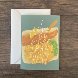 May include: A blue card with a white border and the text "I love you more than chippy teas" in white. The card features an illustration of a fish and chips meal with a lemon wedge.