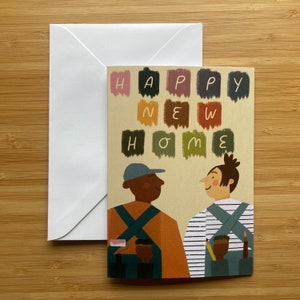 May include: A greeting card with the words "Happy New Home" spelled out in colorful paint swatches. Two people, one with a blue hat and one with brown hair, are smiling at each other. They are both wearing overalls and holding paint brushes.