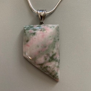 May include: A silver chain necklace with a pendant made of a green and pink stone. The stone has a unique marbled pattern.