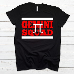 May include: Black t-shirt with a white and red graphic that says "Gemini Squad" with the Gemini zodiac symbol in white.