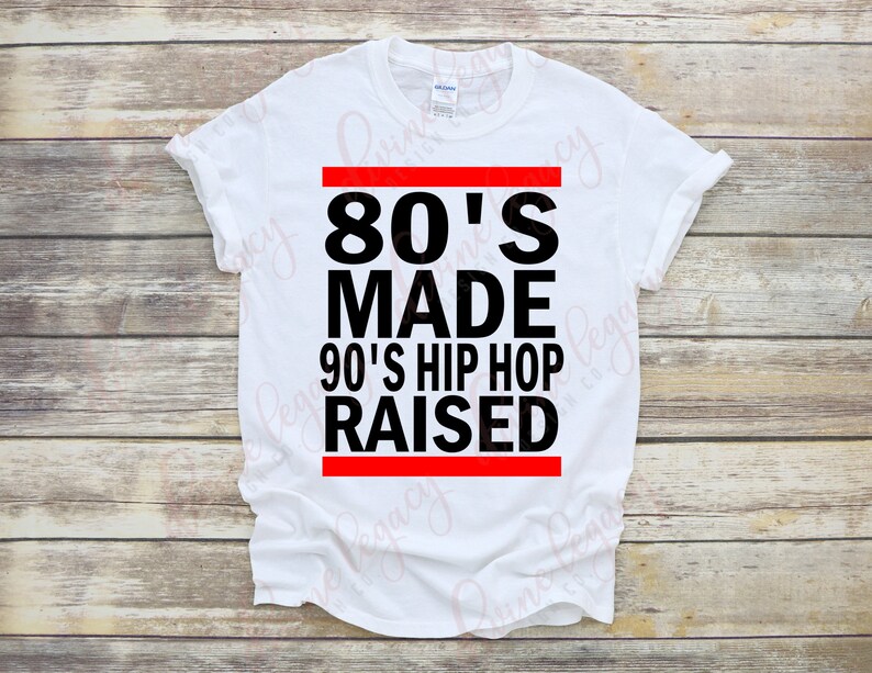 May include: White t-shirt with black text that reads "80's Made 90's Hip Hop Raised" with a red stripe above and below the text.