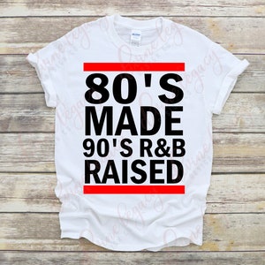 May include: White t-shirt with black text that reads "80's Made 90's R&B Raised" with a red bar above and below the text.