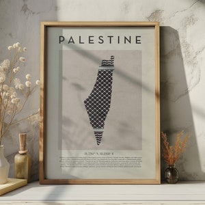 May include: A framed print with the word "PALESTINE" in black text at the top. The print features a black and white map of Palestine with a traditional Palestinian keffiyeh pattern. The coordinates "31.7741&deg; N, 35.2180&deg; E" are printed below the map.