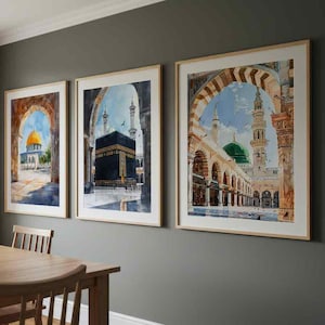 May include: Three framed watercolor prints depicting Islamic architecture. The artwork features a golden dome, the Kaaba, and a mosque with a green dome. The frames are light-colored wood, and the art hangs on a gray wall.