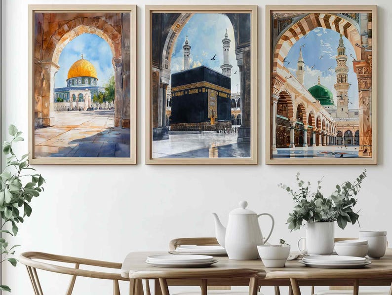 May include: Set of three framed watercolor prints depicting Islamic architecture. The artwork features a golden-domed building, the Kaaba, and a mosque with a green dome. Each print is framed in a light-colored wooden frame, creating a cohesive set.