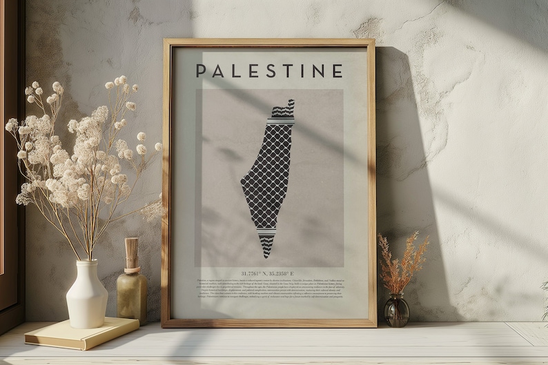 May include: A framed print with the word "PALESTINE" in black text at the top. The print features a black and white map of Palestine with a traditional Palestinian keffiyeh pattern. The coordinates "31.7741&deg; N, 35.2180&deg; E" are printed below the map.